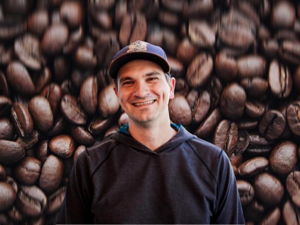 0xCoffee Founder Wade Preston standing in front of coffee beans from Prevail Coffee Alabama
